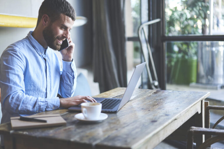 Homem mexendo no computador para fazer transferência pela Azimo.