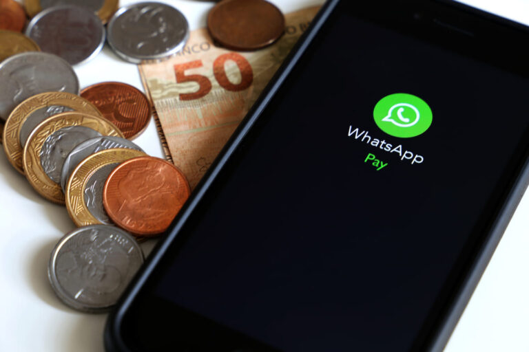 Celular com WhatsApp Pay na tela.