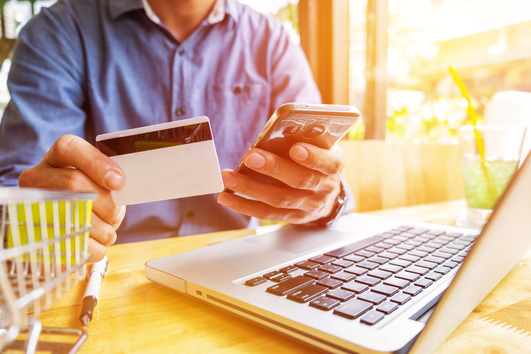 Homem escolhendo fazer compra entre cartões virtuais e tradicionais