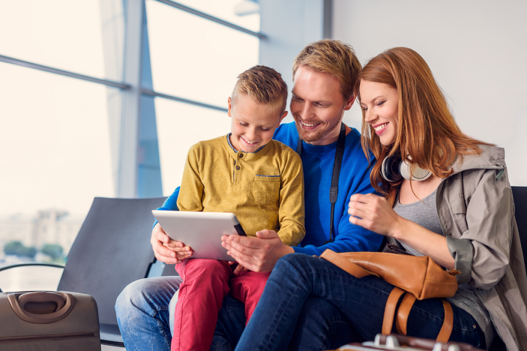 família mexendo no tablet sentados no sofá  