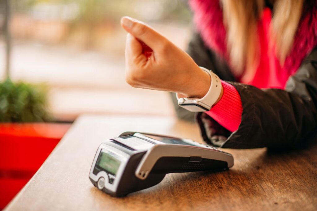 Mulher fazendo pagamento por aproximação com Google Pay.