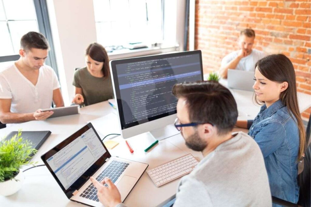 Equipe de trabalho consultando o Stack Overflow para tirar dúvidas sobre programação. 