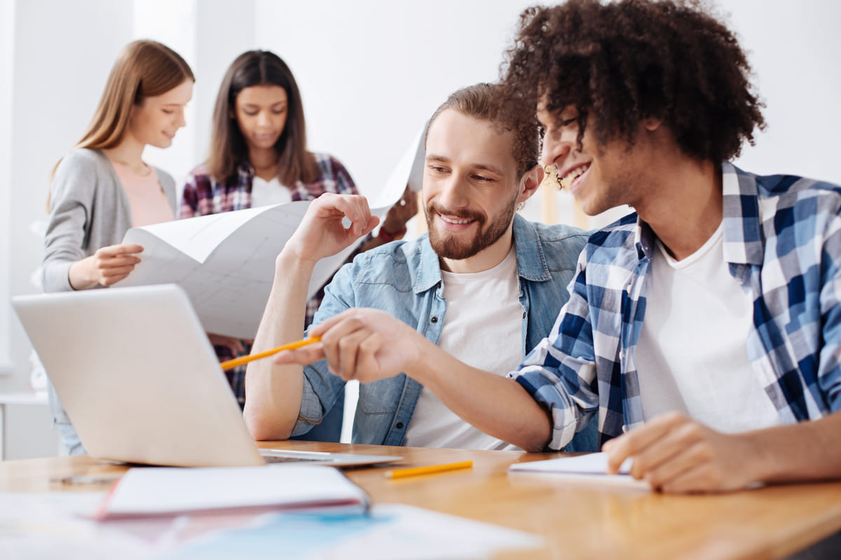 Homens trabalhando em um notebook e pesquisando sobre soft skills