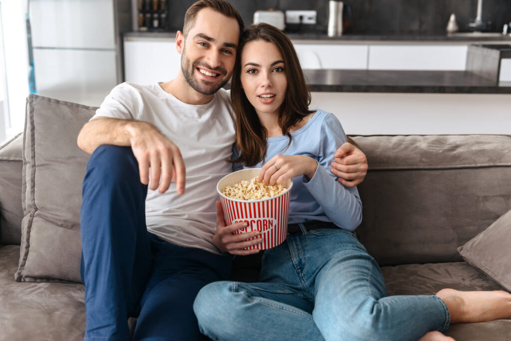 Casal assistindo filmes sobre investimento.