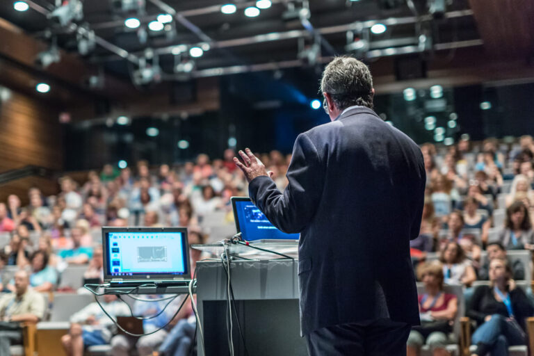 Homem palestrando em evento parecido com o CQCS Insurtech 2022.