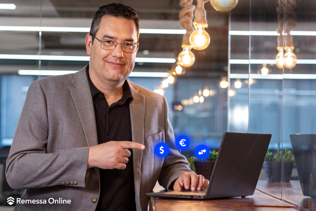 Eduardo Barão sentado em frente a um notebook apontando para a tela