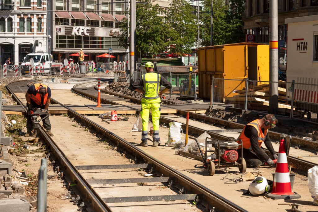 Homens em um trilho de trem simulando trabalhar na Holanda sendo brasileiro