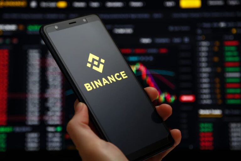 Pessoa segurando celular com logo da Binance para falar que Binance foi hackeada