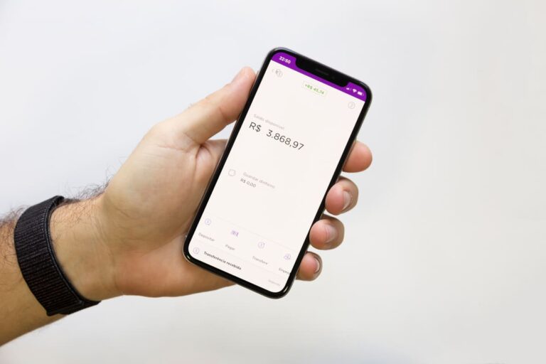 Mão segurando um celular com o aplicativo do Nubank aberto mostrando Nucoin