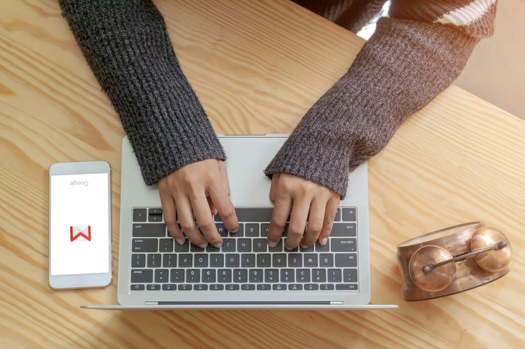 Imagem mostra pessoa digitando no notebook para ver os recursos do Gmail