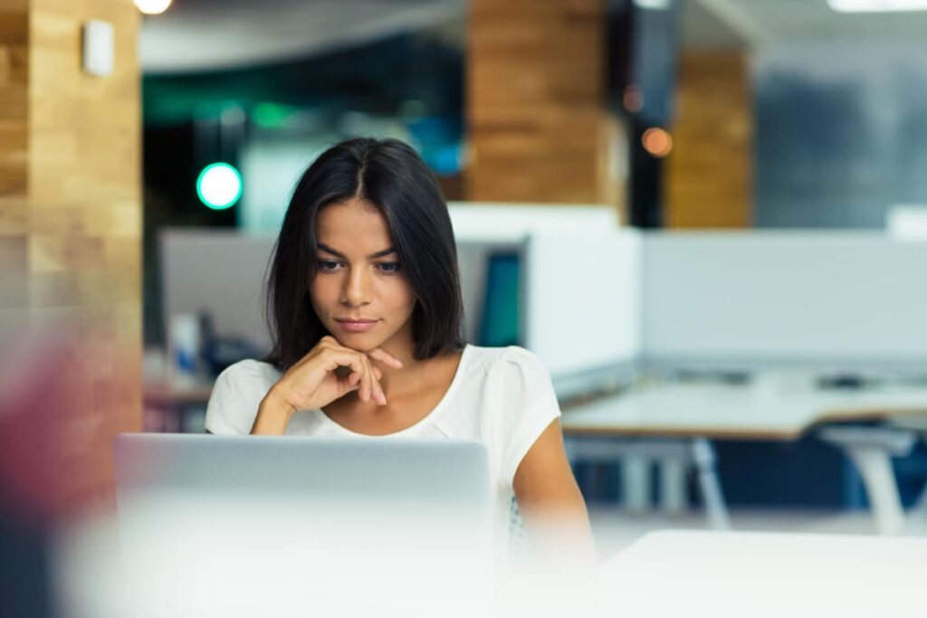 Mulher olhando no notebook as diferenças entre Google Docs e Word.