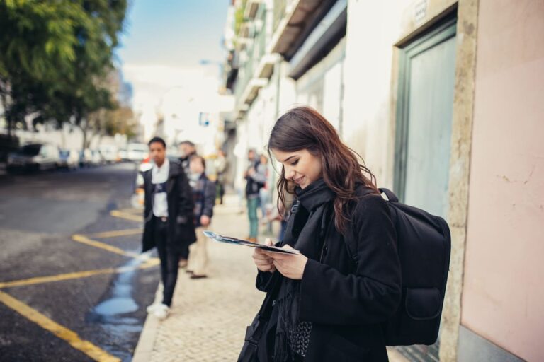 Mulher olhando revista para conferir a Lei de Estrangeiros em Portugal.