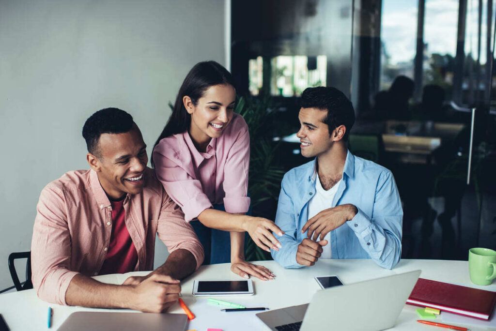 Colaboradores trabalhando juntos e dividindo um espaço de coworking.
