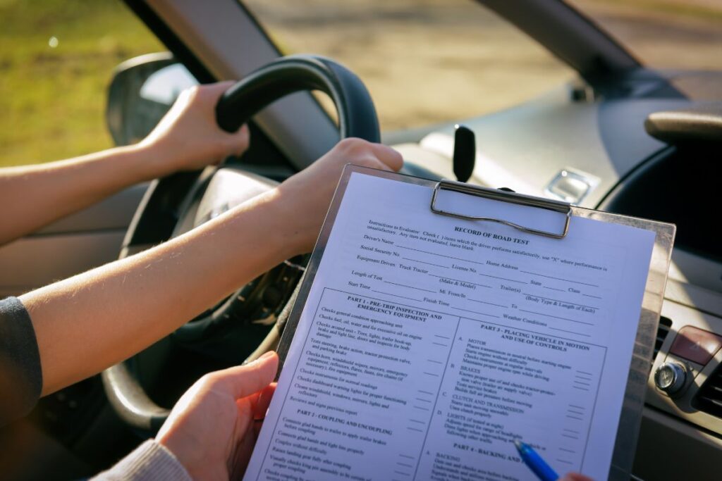 Professor com formulário para tirar carteira de motorista na França dentro do carro. 