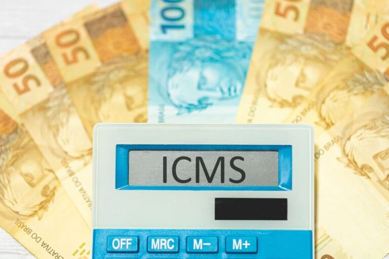 A sigla ICMS referente ao Imposto sobre Circulação de Mercadorias e Serviços escrita na tela de uma calculadora com Real, para ilustrar um texto sobre Incentivos fiscais de ICMS