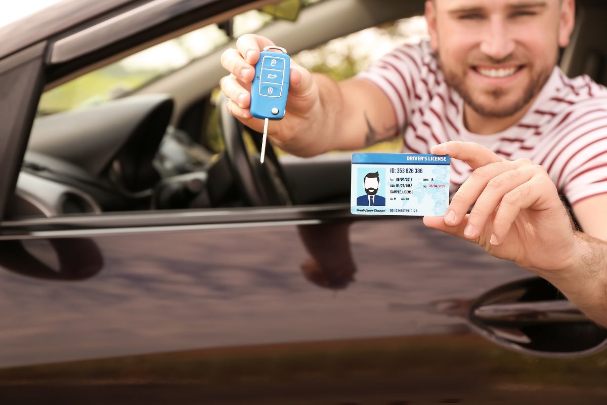 Homem feliz no carro após tirar carteira de motorista na Itália.