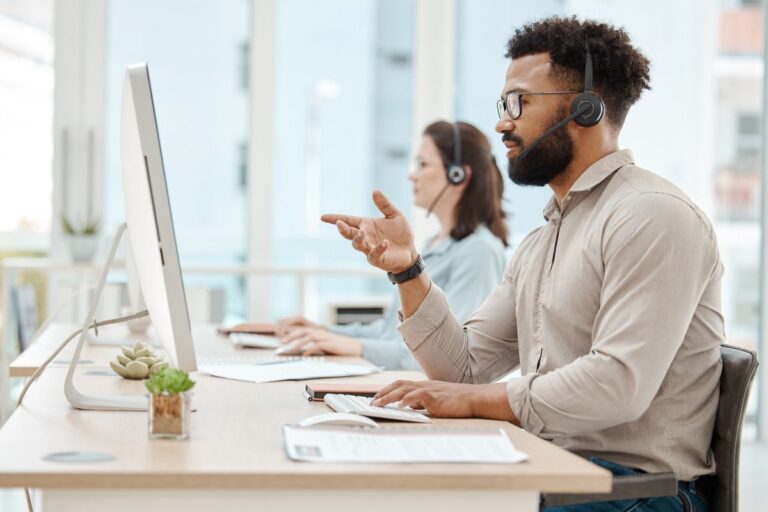 Atendente de telemarketing usando o Zendesk no computador do trabalho.