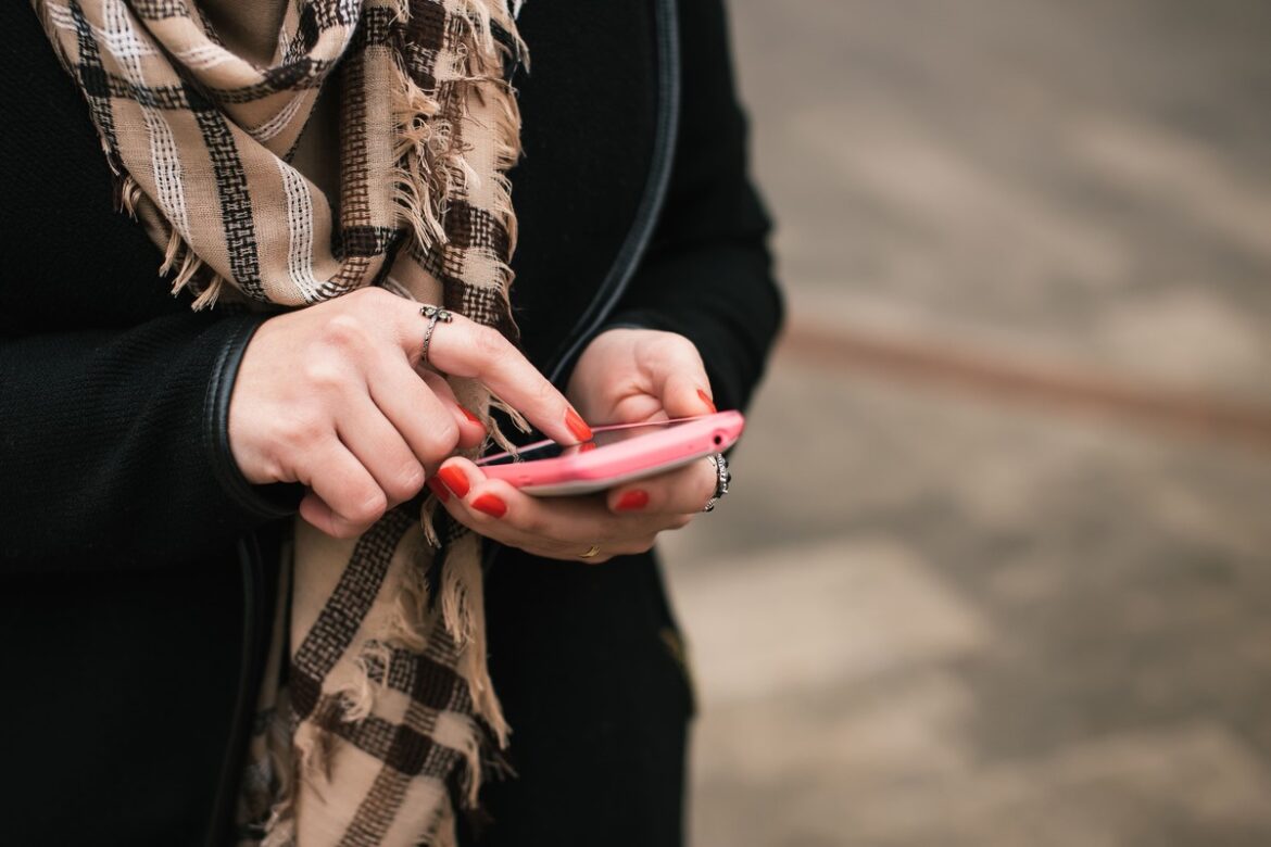 Mulher usando o celular para conferir a opção do nubank operadora telefonia