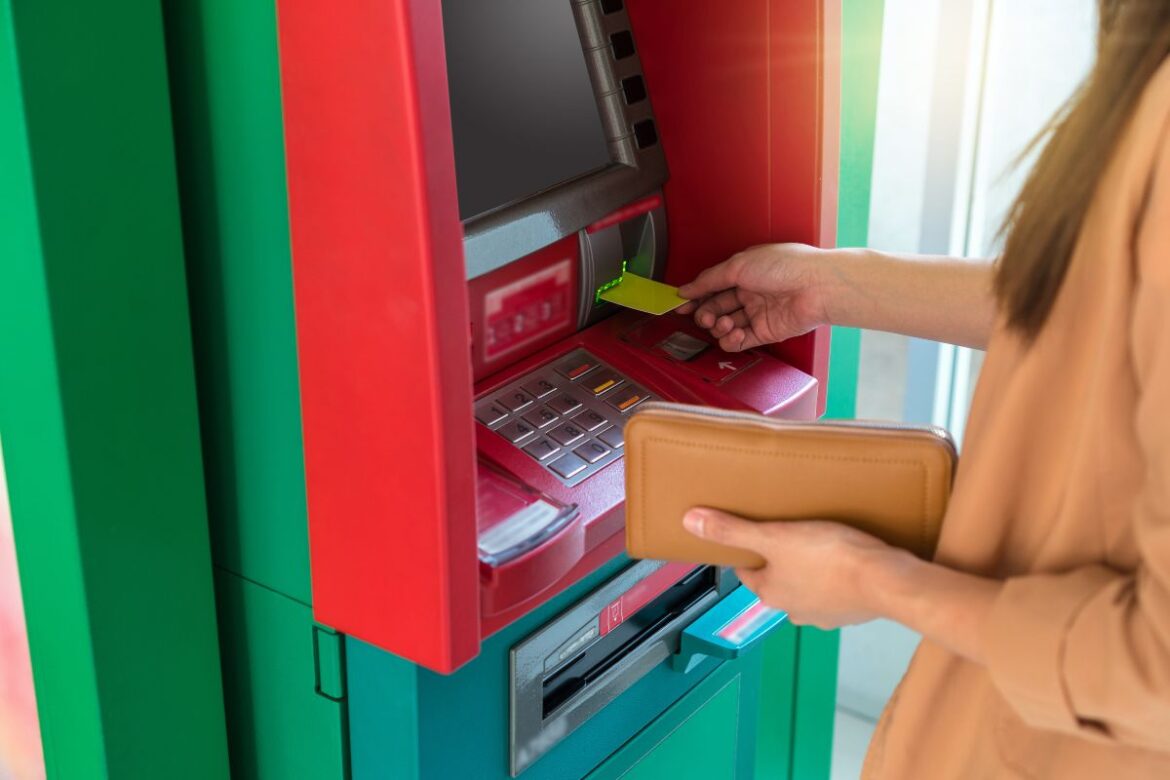 Mulher sacando dinheiro na Argentina em caixa ATM.